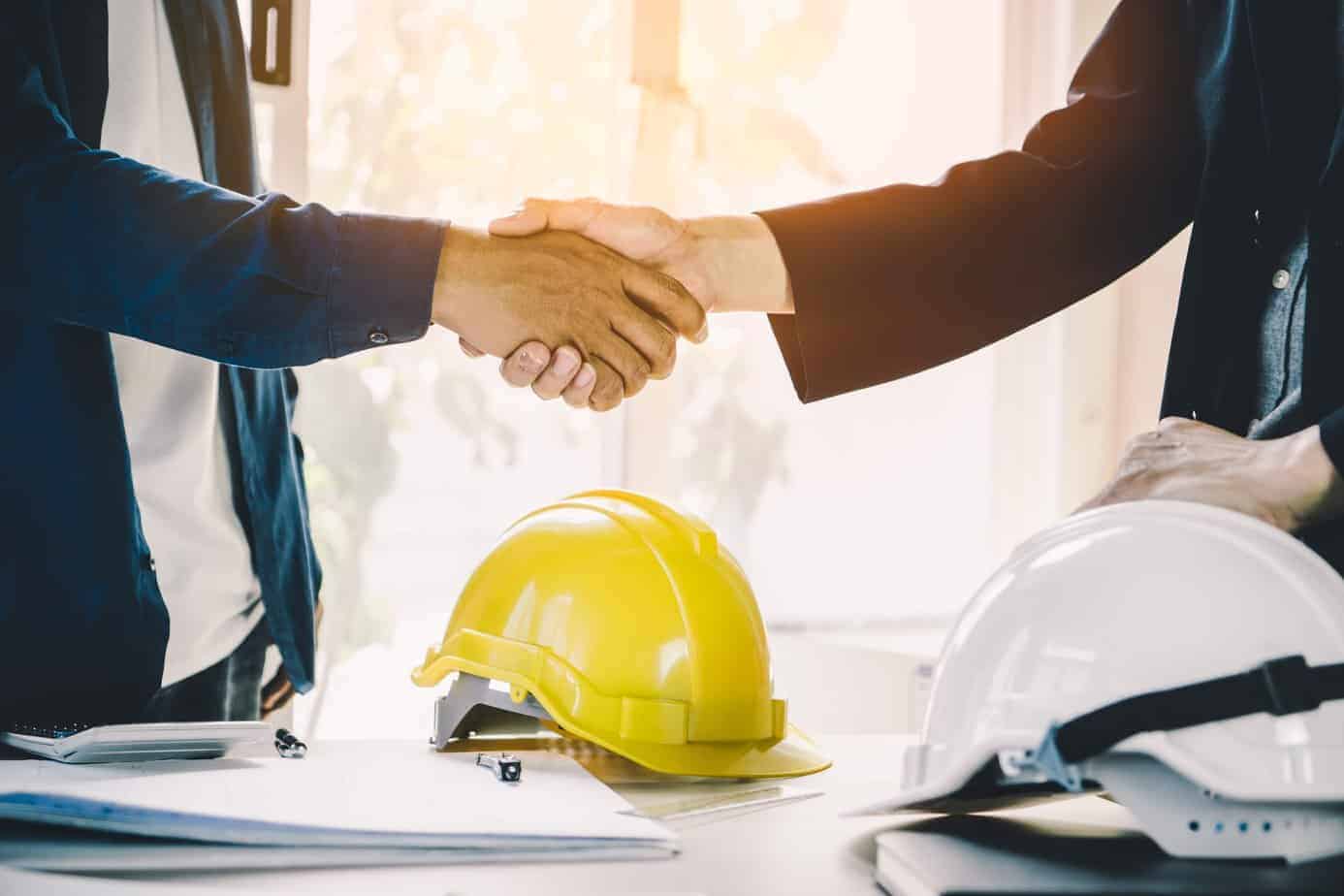 A builder meeting an architect on site to discuss a higher value construction project